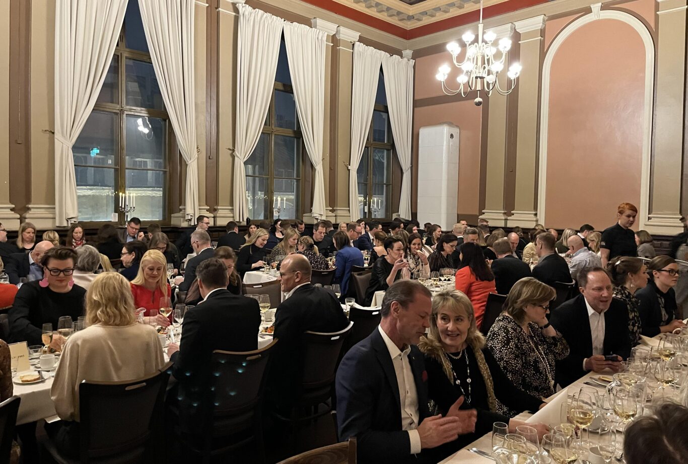 Alumneja istumassa illallisella Ravintola Koulun tunnelmallisessa Bellman-salissa vuoden 2023 Tiedekunnan päivässä.